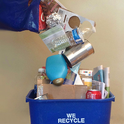 Recyclable materials falling loose into a curbside bin